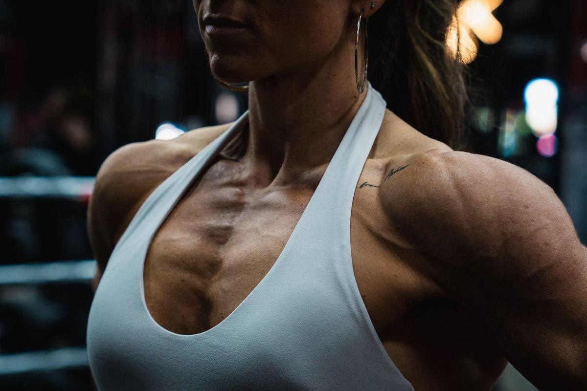 Chest and shoulder detail of a female athlete in a white halter top