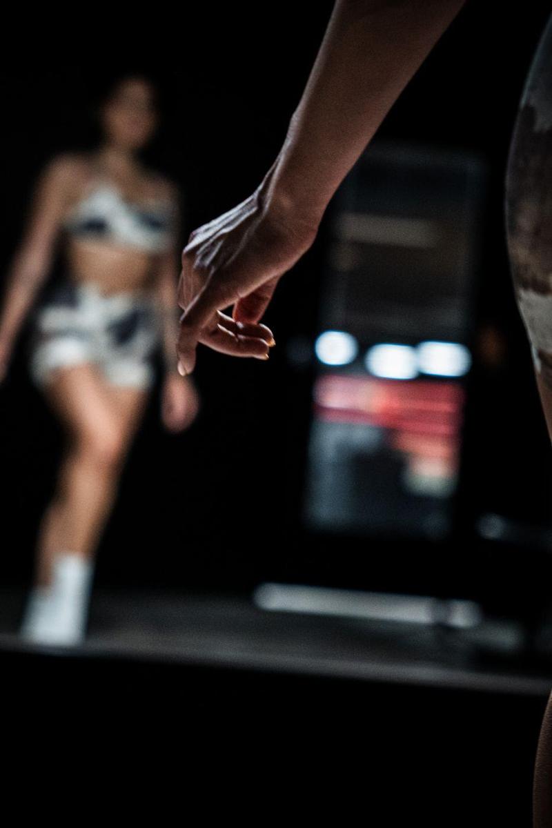 Posing hand in focus, the athlete blurred in the mirror behind